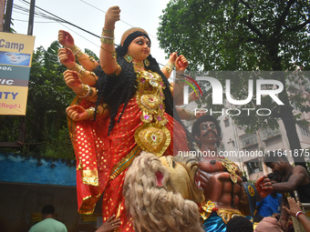 Workers load a Durga idol onto a truck for transport to a pandal, or a temporary platform, ahead of the Durga Puja festival in Kolkata, Indi...