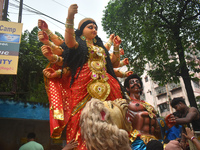 Workers load a Durga idol onto a truck for transport to a pandal, or a temporary platform, ahead of the Durga Puja festival in Kolkata, Indi...