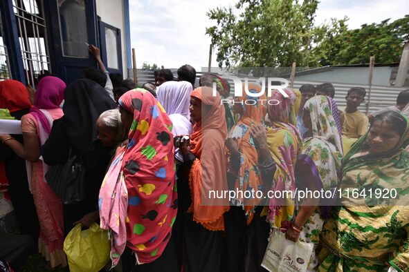 People wait in queue to check their names on the draft list at the National Register of Citizens (NRC) center in a village in Nagaon distric...