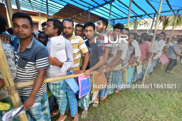 People wait in queue to check their names on the draft list at the National Register of Citizens (NRC) center in a village in Nagaon distric...