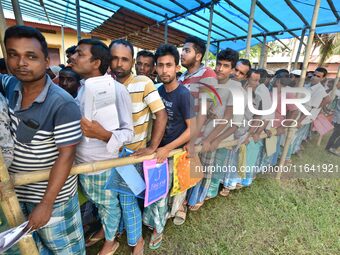 People wait in queue to check their names on the draft list at the National Register of Citizens (NRC) center in a village in Nagaon distric...