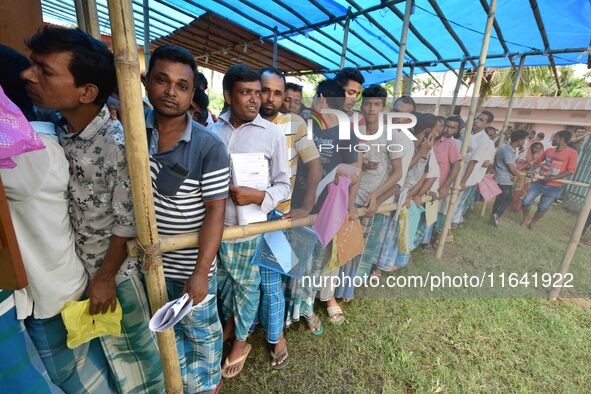 People wait in queue to check their names on the draft list at the National Register of Citizens (NRC) center in a village in Nagaon distric...