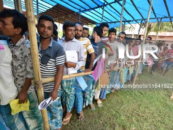 People wait in queue to check their names on the draft list at the National Register of Citizens (NRC) center in a village in Nagaon distric...