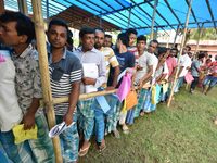 People wait in queue to check their names on the draft list at the National Register of Citizens (NRC) center in a village in Nagaon distric...