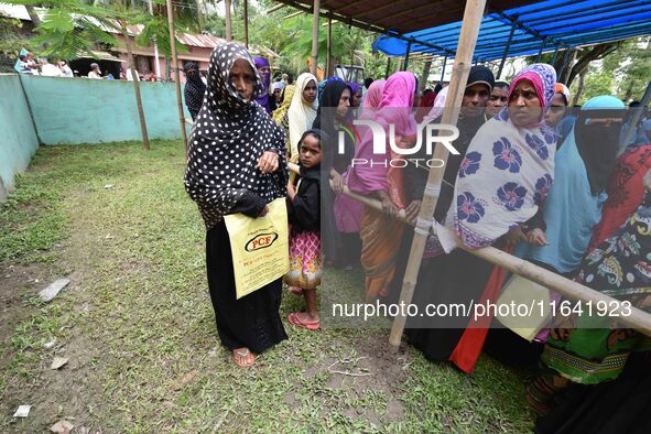 People wait in queue to check their names on the draft list at the National Register of Citizens (NRC) center in a village in Nagaon distric...