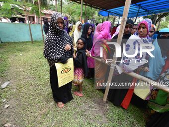 People wait in queue to check their names on the draft list at the National Register of Citizens (NRC) center in a village in Nagaon distric...