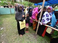 People wait in queue to check their names on the draft list at the National Register of Citizens (NRC) center in a village in Nagaon distric...