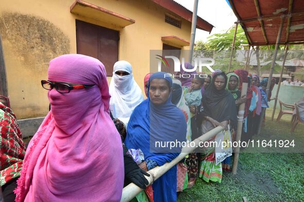 People wait in queue to check their names on the draft list at the National Register of Citizens (NRC) center in a village in Nagaon distric...