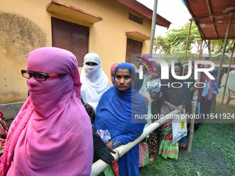 People wait in queue to check their names on the draft list at the National Register of Citizens (NRC) center in a village in Nagaon distric...