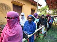 People wait in queue to check their names on the draft list at the National Register of Citizens (NRC) center in a village in Nagaon distric...