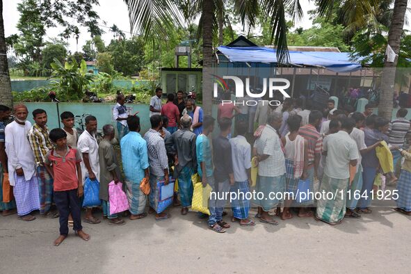 People wait in queue to check their names on the draft list at the National Register of Citizens (NRC) center in a village in Nagaon distric...