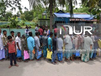 People wait in queue to check their names on the draft list at the National Register of Citizens (NRC) center in a village in Nagaon distric...