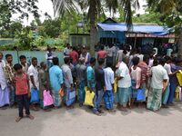 People wait in queue to check their names on the draft list at the National Register of Citizens (NRC) center in a village in Nagaon distric...