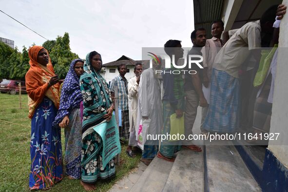 People wait to check their names on the draft list at the National Register of Citizens (NRC) center in a village in Nagaon district, Assam,...