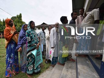 People wait to check their names on the draft list at the National Register of Citizens (NRC) center in a village in Nagaon district, Assam,...