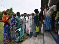 People wait to check their names on the draft list at the National Register of Citizens (NRC) center in a village in Nagaon district, Assam,...