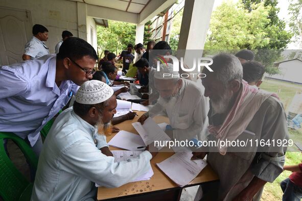 People check their names on the draft list at the National Register of Citizens (NRC) center in a village in Nagaon district, Assam, India,...