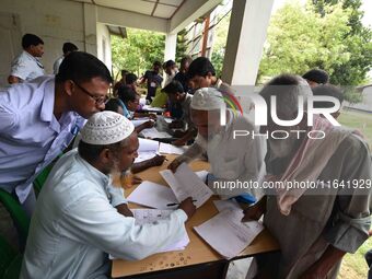 People check their names on the draft list at the National Register of Citizens (NRC) center in a village in Nagaon district, Assam, India,...