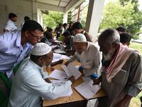 People check their names on the draft list at the National Register of Citizens (NRC) center in a village in Nagaon district, Assam, India,...