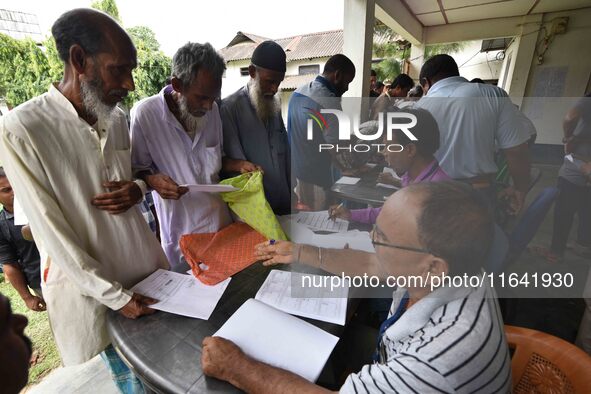 People check their names on the draft list at the National Register of Citizens (NRC) center in a village in Nagaon district, Assam, India,...