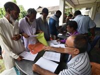 People check their names on the draft list at the National Register of Citizens (NRC) center in a village in Nagaon district, Assam, India,...