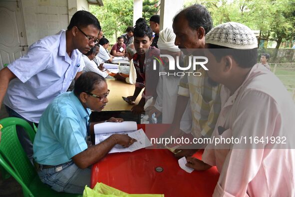 People check their names on the draft list at the National Register of Citizens (NRC) center in a village in Nagaon district, Assam, India,...