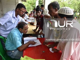 People check their names on the draft list at the National Register of Citizens (NRC) center in a village in Nagaon district, Assam, India,...