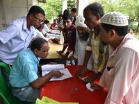 People check their names on the draft list at the National Register of Citizens (NRC) center in a village in Nagaon district, Assam, India,...