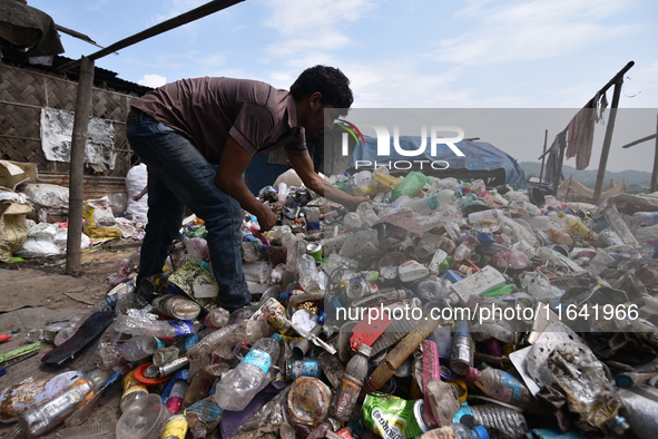 An Indian rag-picker sorts plastic bags at a landfill in the Boragoan area in Guwahati, India, on June 4, 2018. 