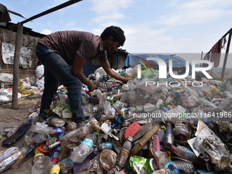 An Indian rag-picker sorts plastic bags at a landfill in the Boragoan area in Guwahati, India, on June 4, 2018. (