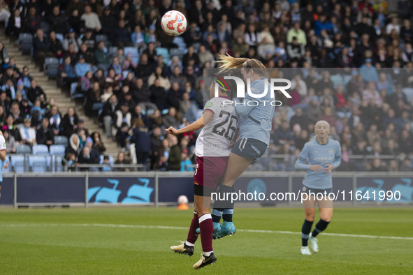 Lauren Hemp #11 of Manchester City W.F.C. engages in an aerial challenge with Li Mengwen #26 of West Ham United F.C. during the Barclays FA...