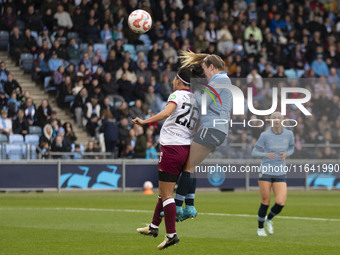 Lauren Hemp #11 of Manchester City W.F.C. engages in an aerial challenge with Li Mengwen #26 of West Ham United F.C. during the Barclays FA...