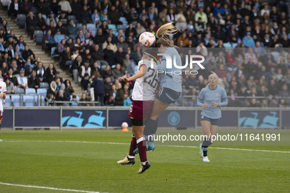 Lauren Hemp #11 of Manchester City W.F.C. engages in an aerial challenge with Li Mengwen #26 of West Ham United F.C. during the Barclays FA...