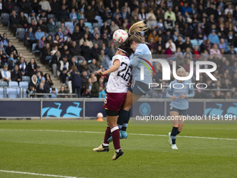 Lauren Hemp #11 of Manchester City W.F.C. engages in an aerial challenge with Li Mengwen #26 of West Ham United F.C. during the Barclays FA...