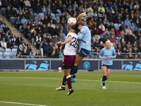 Lauren Hemp #11 of Manchester City W.F.C. engages in an aerial challenge with Li Mengwen #26 of West Ham United F.C. during the Barclays FA...