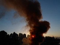 Workers set cables on fire, causing air pollution as they extract copper on the outskirts of Sopore, Jammu and Kashmir, India, on October 6,...