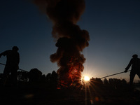 Workers set cables on fire, causing air pollution as they extract copper on the outskirts of Sopore, Jammu and Kashmir, India, on October 6,...