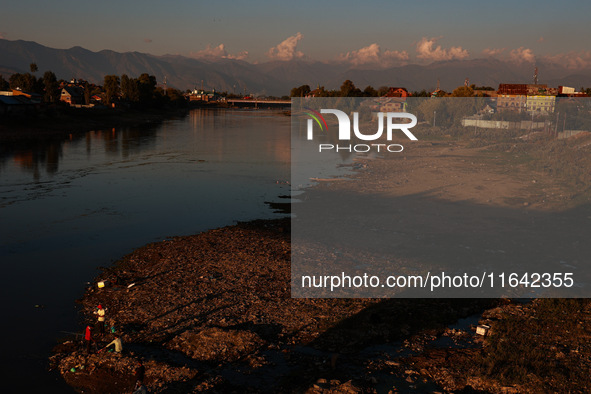 Kashmiri men catch fish on the dried portion of the River Jhelum as the water level of the river decreases in Sopore, Jammu and Kashmir, Ind...