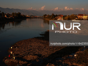 Kashmiri men catch fish on the dried portion of the River Jhelum as the water level of the river decreases in Sopore, Jammu and Kashmir, Ind...