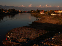 Kashmiri men catch fish on the dried portion of the River Jhelum as the water level of the river decreases in Sopore, Jammu and Kashmir, Ind...