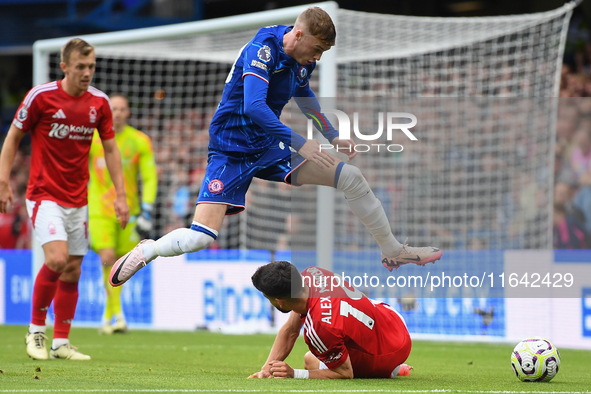 Cole Palmer of Chelsea jumps over Alex Moreno of Nottingham Forest during the Premier League match between Chelsea and Nottingham Forest at...