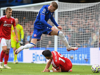 Cole Palmer of Chelsea jumps over Alex Moreno of Nottingham Forest during the Premier League match between Chelsea and Nottingham Forest at...