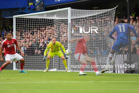 Noni Madueke of Chelsea shoots at goal as Matz Sels, Nottingham Forest goalkeeper, makes a save during the Premier League match between Chel...