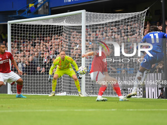 Noni Madueke of Chelsea shoots at goal as Matz Sels, Nottingham Forest goalkeeper, makes a save during the Premier League match between Chel...