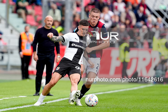 Emil Holm of Bologna FC and Dennis Man of Parma Calcio 1903 compete for the ball during the Serie A Enilive match between Bologna FC and Par...