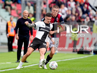 Emil Holm of Bologna FC and Dennis Man of Parma Calcio 1903 compete for the ball during the Serie A Enilive match between Bologna FC and Par...