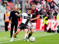 Emil Holm of Bologna FC and Dennis Man of Parma Calcio 1903 compete for the ball during the Serie A Enilive match between Bologna FC and Par...