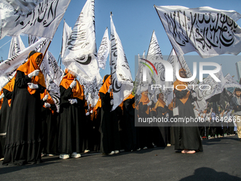 Muslims hold up posters during a pro-Palestinian rally on the eve of the one-year anniversary of the Israel-Hamas conflict in Surabaya, Indo...