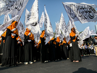 Muslims hold up posters during a pro-Palestinian rally on the eve of the one-year anniversary of the Israel-Hamas conflict in Surabaya, Indo...