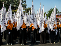 Muslims hold up posters during a pro-Palestinian rally on the eve of the one-year anniversary of the Israel-Hamas conflict in Surabaya, Indo...